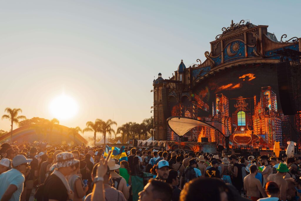 Pôr do sol no palco The Gathering, com multidão reunida no DreamVille durante o Tomorrowland Brasil