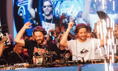 Dupla Dubdogz se apresenta ao vivo em evento no estilo Summer Eletrohits, com público animado e atmosfera nostálgica.