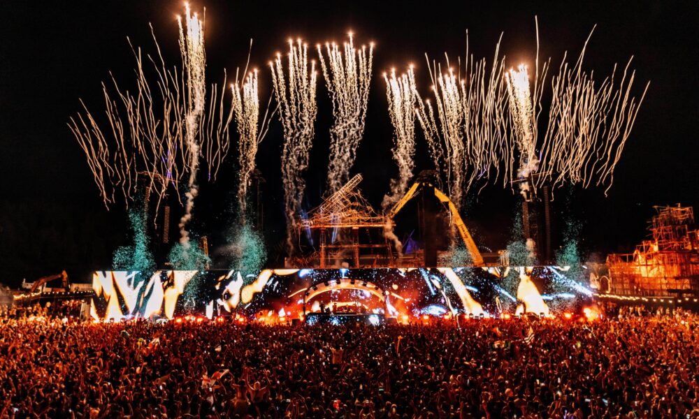 Mainstage do Tomorrowland 2025 em Boom, Bélgica, com show de fogos de artifício e milhares de fãs celebrando o festival de música eletrônica.