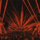 Time Warp Brasil com multidão em festival de techno e iluminação intensa, com estética gritty inspirada em pôster underground