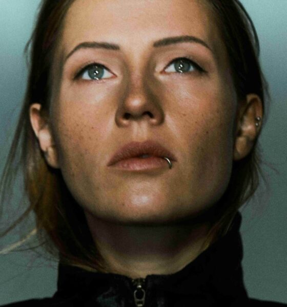 Charlotte de Witte com relógio Tudor de mostrador azul claro ao lado de equipamento de estúdio